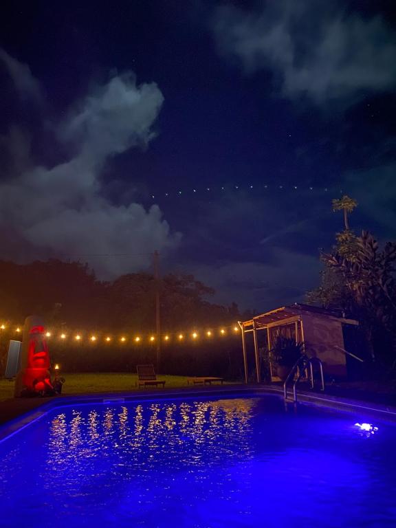 NaalehuHawaii Island Resort的游泳池在晚上点亮,灯光照亮