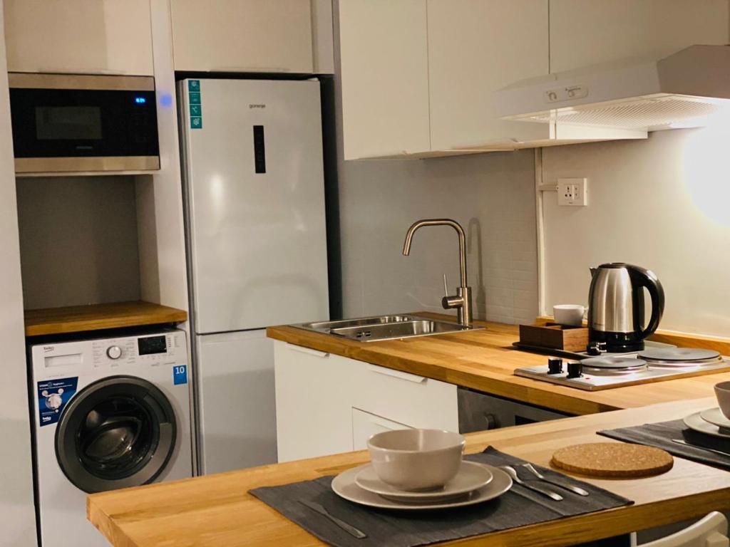 Ţāb Kirā‘Elite Corner Apartment的厨房配有水槽和冰箱