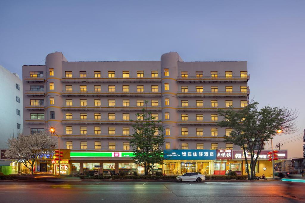 济南银座佳驿济南大明湖火车站店的一座大型建筑,前面有停车位