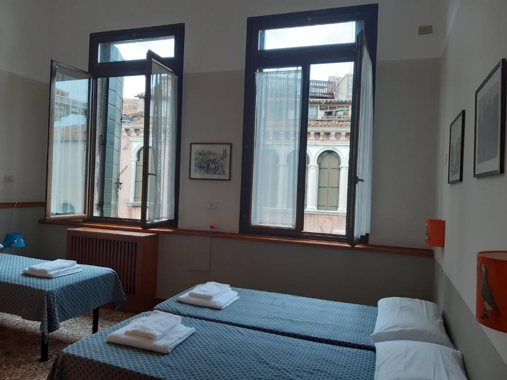 威尼斯威尼斯瓦迪赛旅舍的带2扇窗户的客房内的2张床