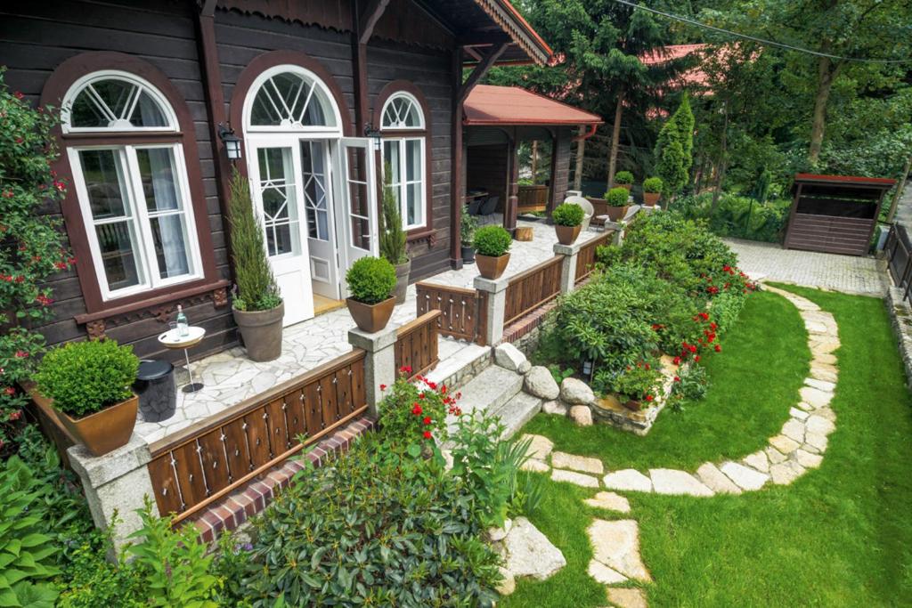 卡尔帕奇Dom Karpacz的种有盆栽植物和房屋的花园