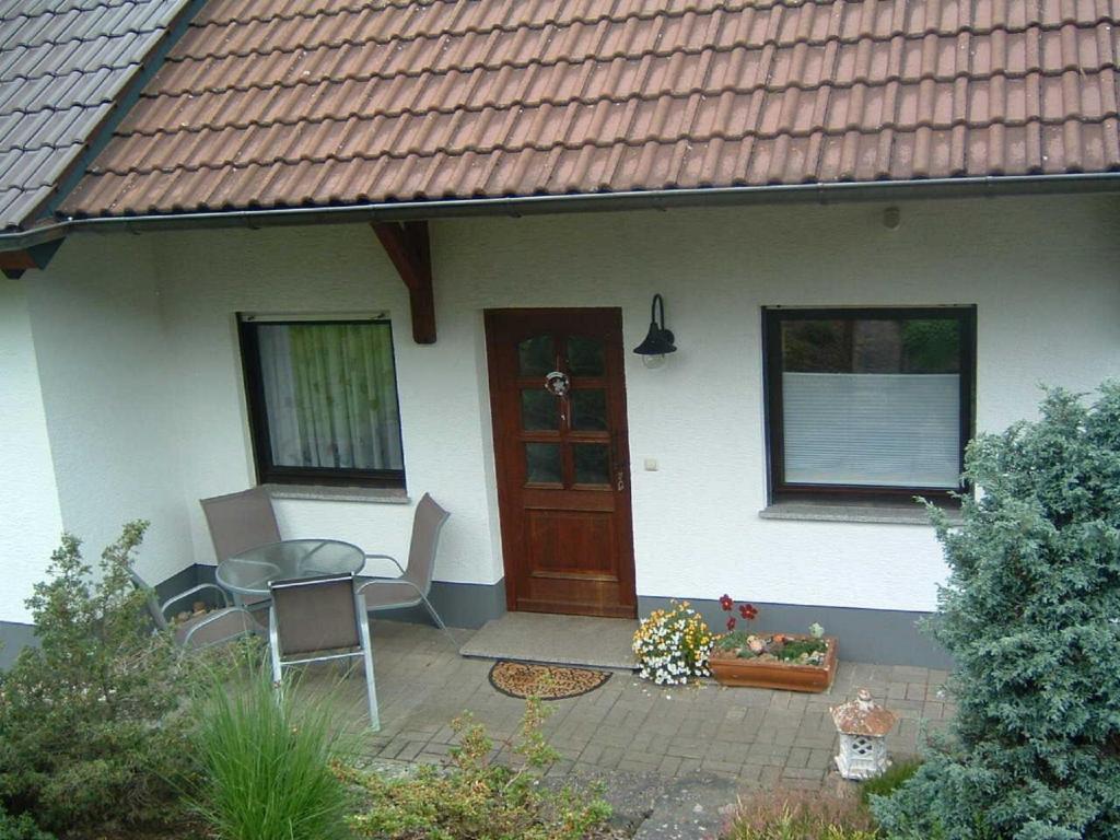 RiedenbergFerienwohnung Hergenröder的房屋设有带桌椅的庭院