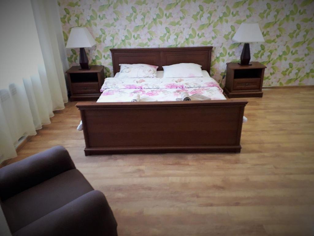 Novyye PetrovtsyGuest house on Ivana Franka的一间卧室配有带2个床头柜和1张沙发的床