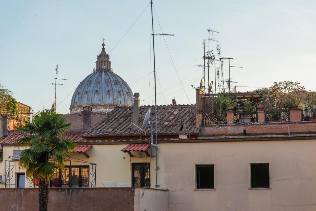 罗马罗萨迪博尔戈门梵蒂冈豪华套房公寓的一座有圆顶的建筑,背靠棕榈树