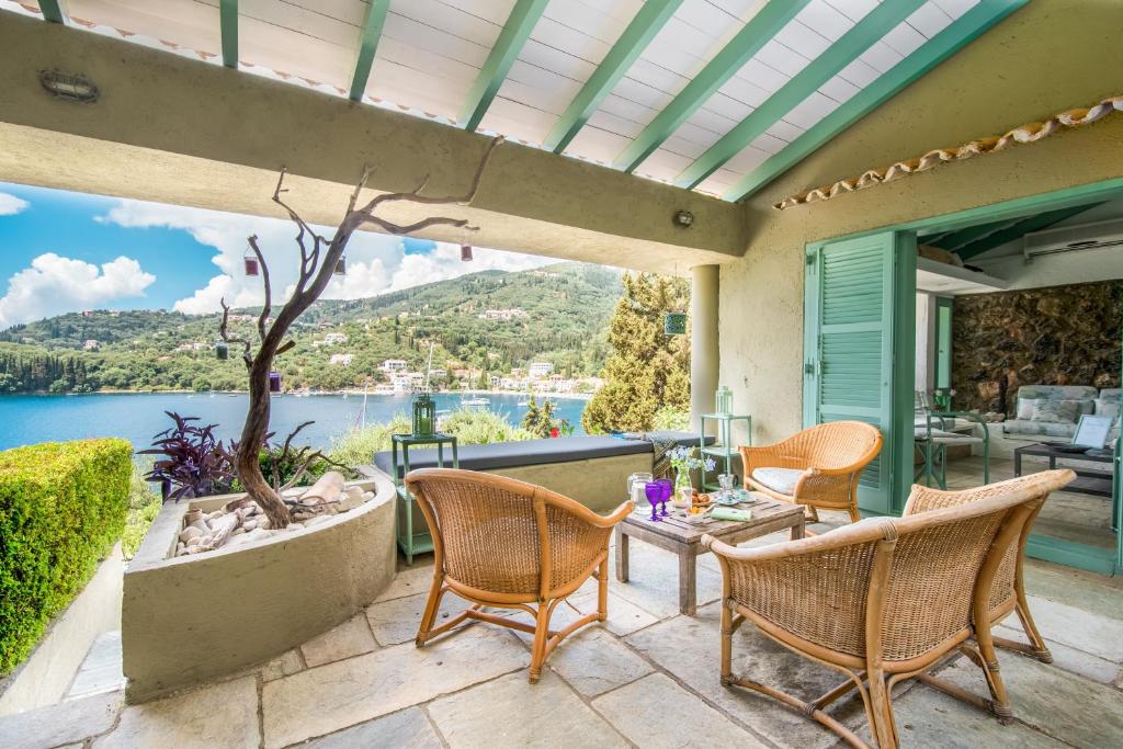 卡拉米kala.mia charming sea view villa的一个带桌椅的庭院,享有水景