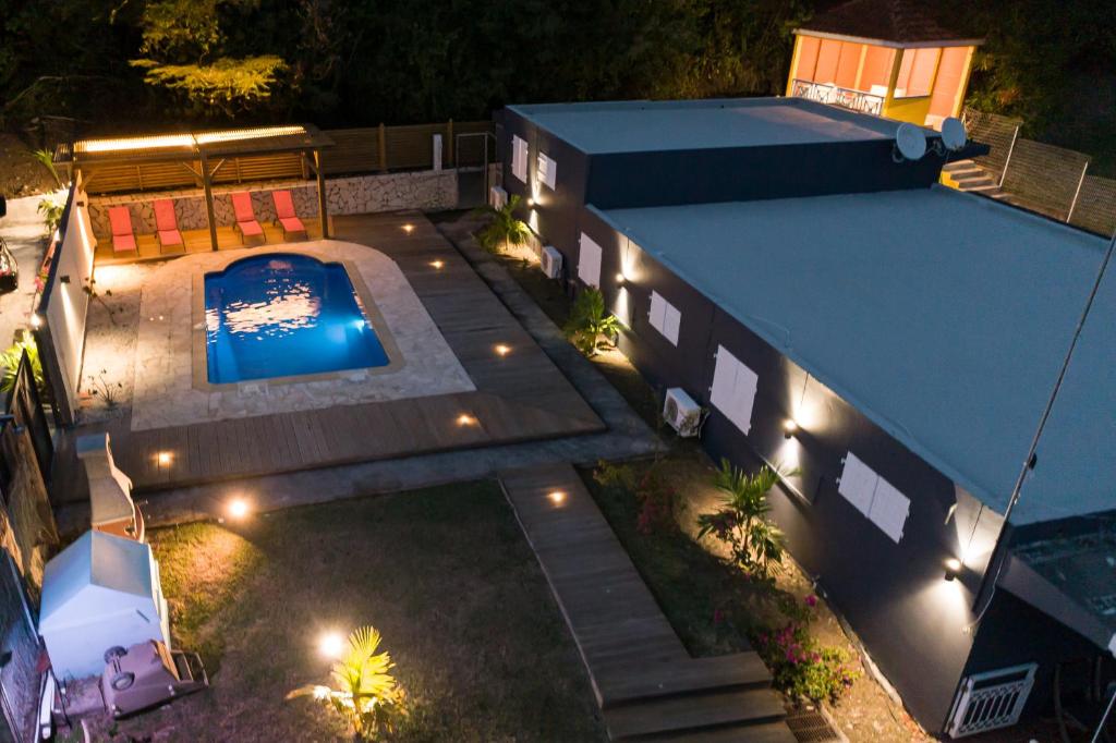 勒罗贝尔La villa IXORAS的享有房子顶部的景色,晚上设有游泳池