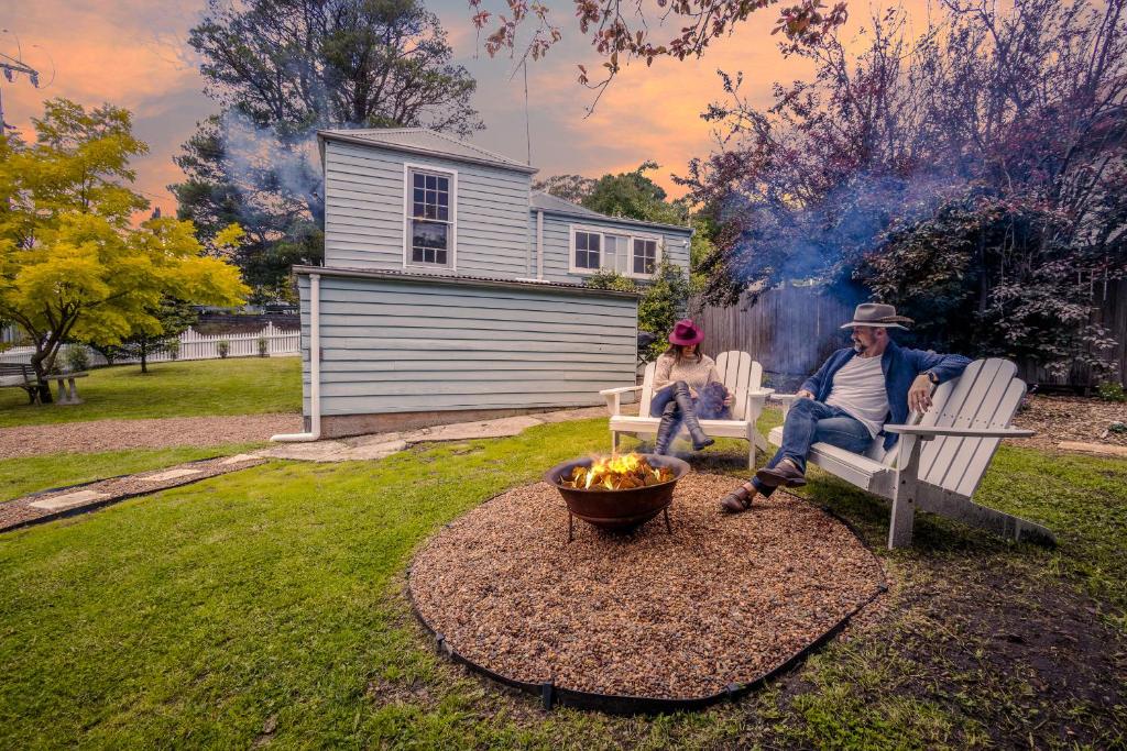 维多利亚山Pet-Friendly Blue Mountains Cottage with Indoor Fireplace的两个人坐在火坑旁的长凳上