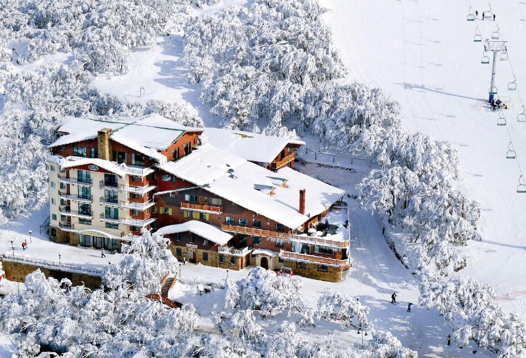 布勒山格里莫斯酒店的雪地中的滑雪小屋,有雪覆盖的树木