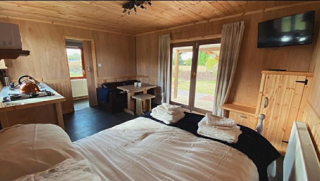 TuxfordBeautiful Wooden tiny house, Glamping cabin with hot tub 3的一间带床的卧室,位于带窗户的房间内