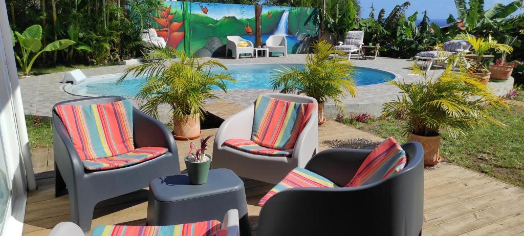 三河市Un coin de paradis, piscine privative, vue Saintes的一组椅子坐在游泳池旁