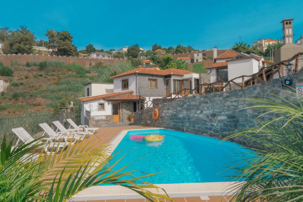 卡列塔Vila Maria Quinta 13的一个带椅子的游泳池以及一座房子