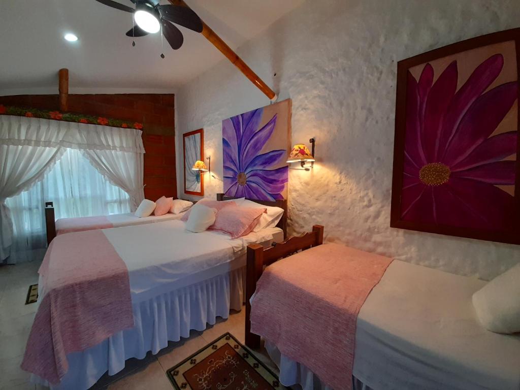 金巴亚Villa Luzandi的一间卧室设有两张床,墙上挂着一幅画