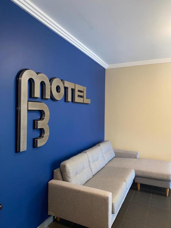 悉尼The Bexley Motel的一间配有沙发的房间和一面墙,上面有b字型