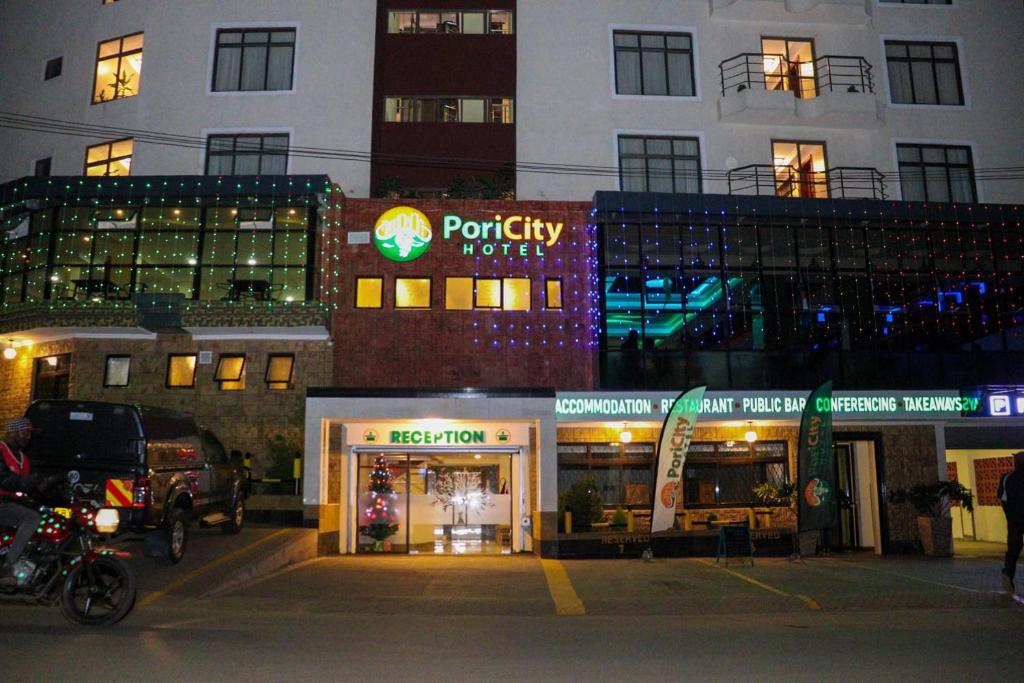 内罗毕Pori City Hotel的一间晚上在建筑物前的商店