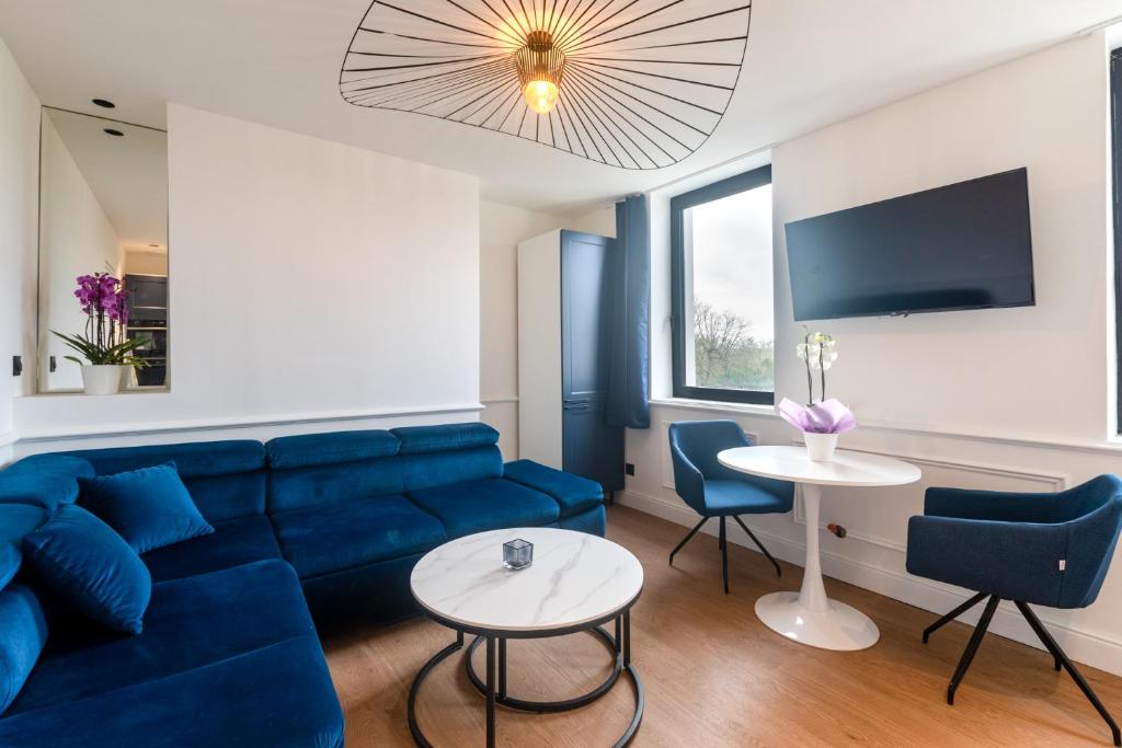 BelbeufStudios Le Medicis vue Seine的客厅配有蓝色的沙发和桌子