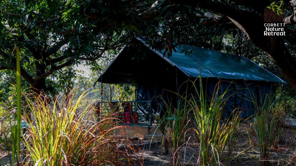 兰纳加Corbett Nature Retreat的蓝色帐篷,里面坐着人