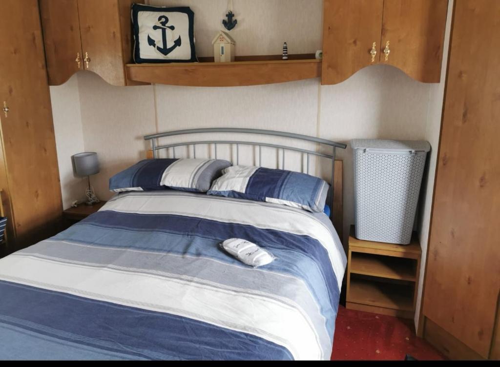 赫彻姆Heacham South Beach static caravan的一间卧室配有蓝色和白色床单