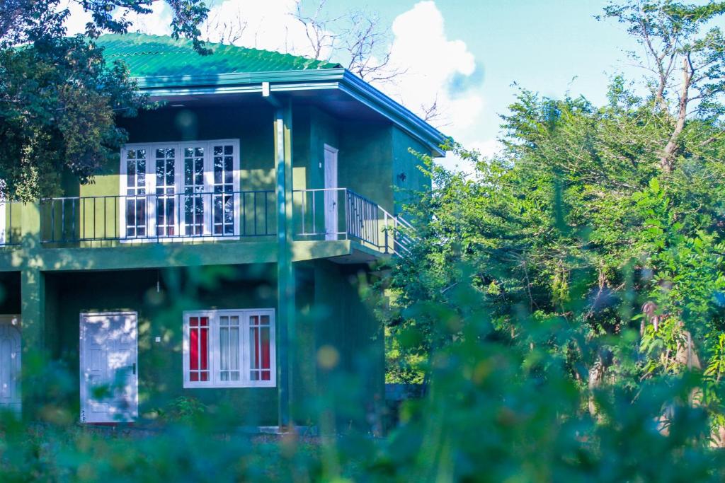 锡吉里亚Pavona Lake的带阳台和红色门的绿色房屋