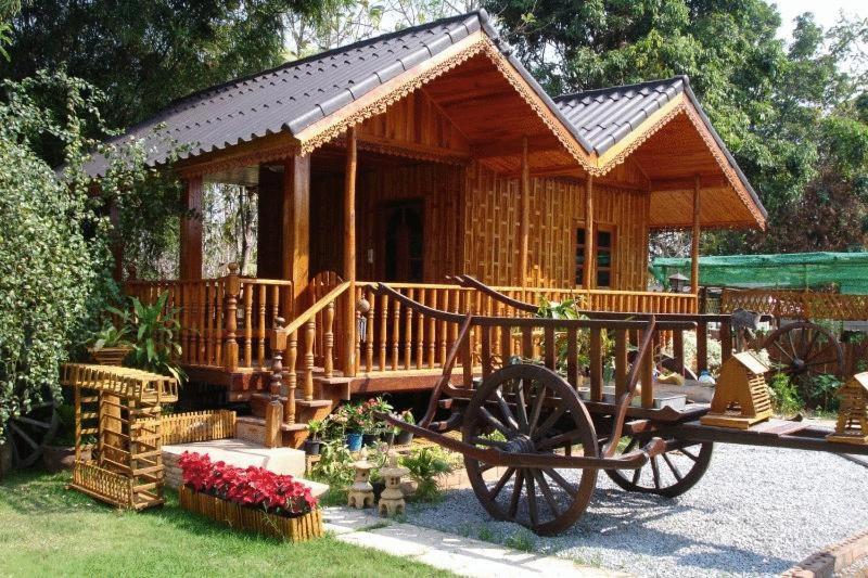 乌隆他尼斯塔住宿加早餐民宿的前面有马车的小木屋