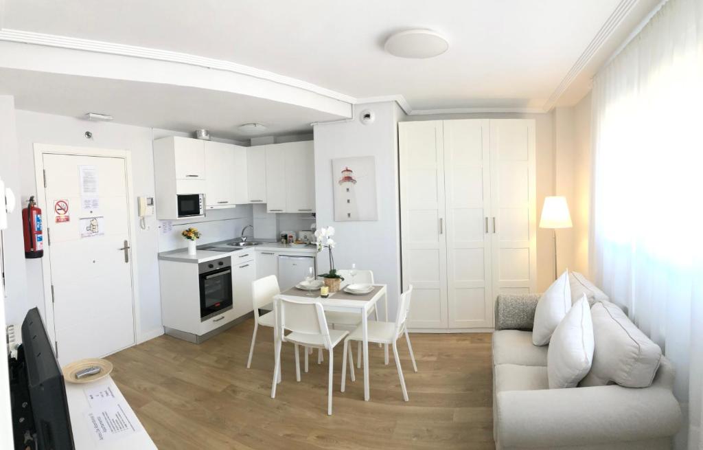 乌迪亚莱斯堡Apto Vistas Mar y Monte Céntrico Garaje Incluido的厨房以及带桌子和沙发的客厅。