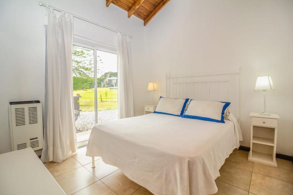 坦迪尔Abril Village的白色的卧室设有床和窗户