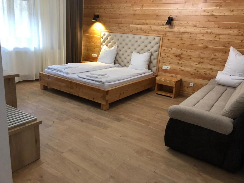 阿尔巴克Pensiunea Armonia Albac的一间卧室配有一张床和一张沙发