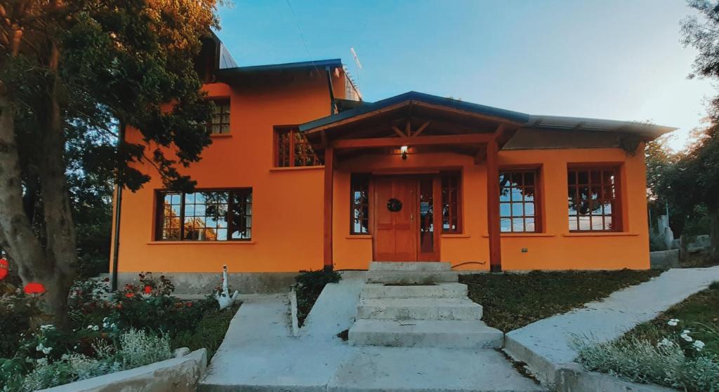 圣卡洛斯-德巴里洛切Alojamiento Los Alelies的一座橙色的房子,有楼梯通往
