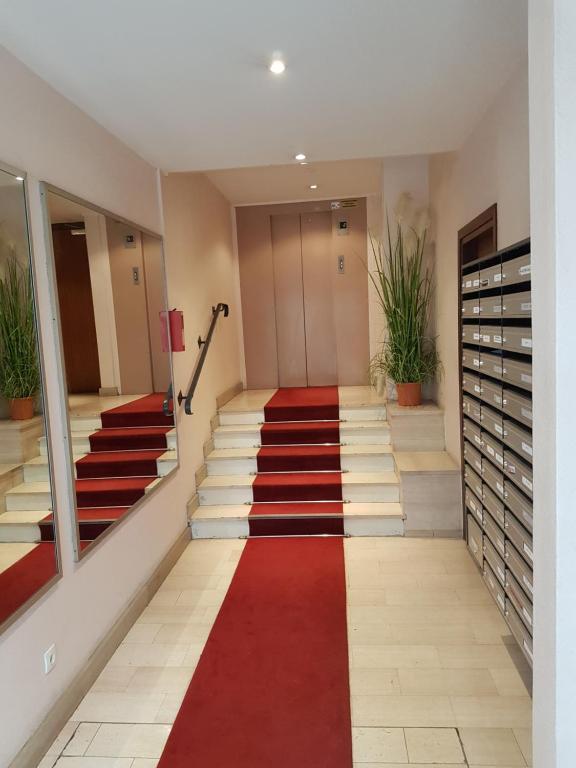 枫丹白露Studio cosy Fontainebleau hyper centre JO2024的走廊上铺有红色地毯,设有楼梯