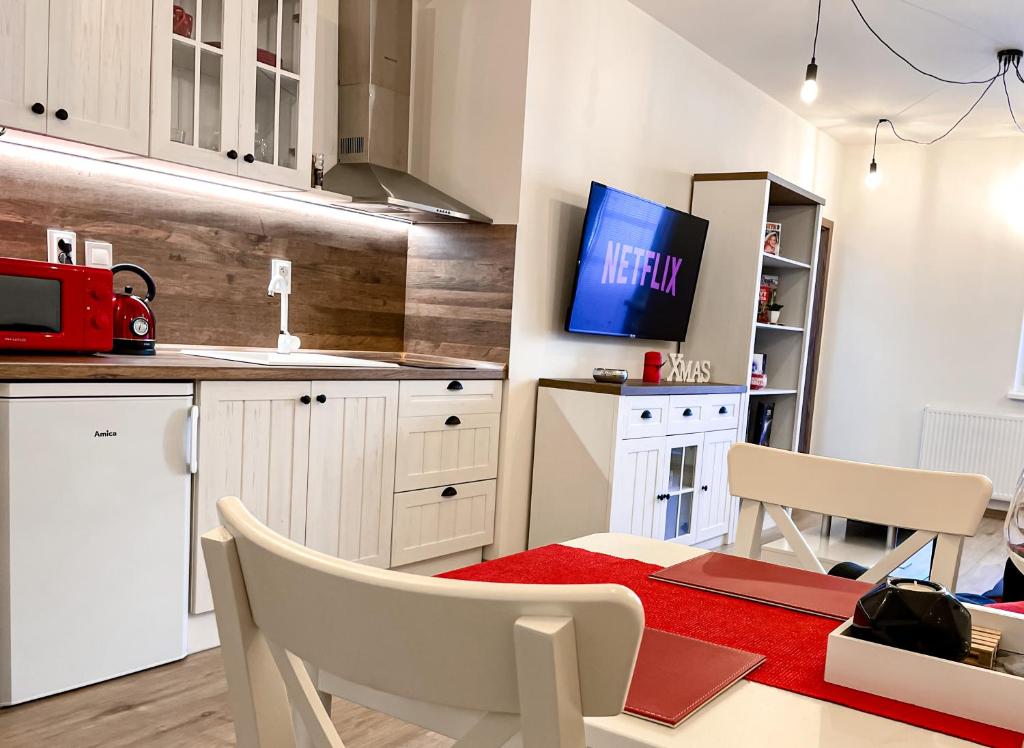 日利纳Apartmán Rajecké Teplice的厨房配有桌子,墙上配有电视。