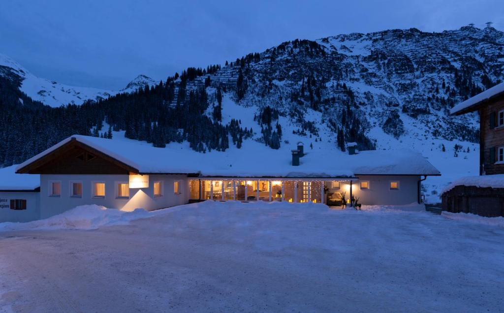 莱赫阿尔贝格Chalet Schneekristall的夜晚雪中灯火通明的房子