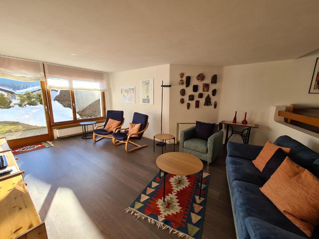 弗利姆斯Alpen-fewo, Denter Vias 10, Casa Alma的客厅配有蓝色的沙发和椅子