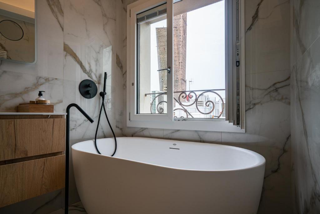 博洛尼亚PANORAMA APARTMENT的带窗户的浴室内的白色浴缸