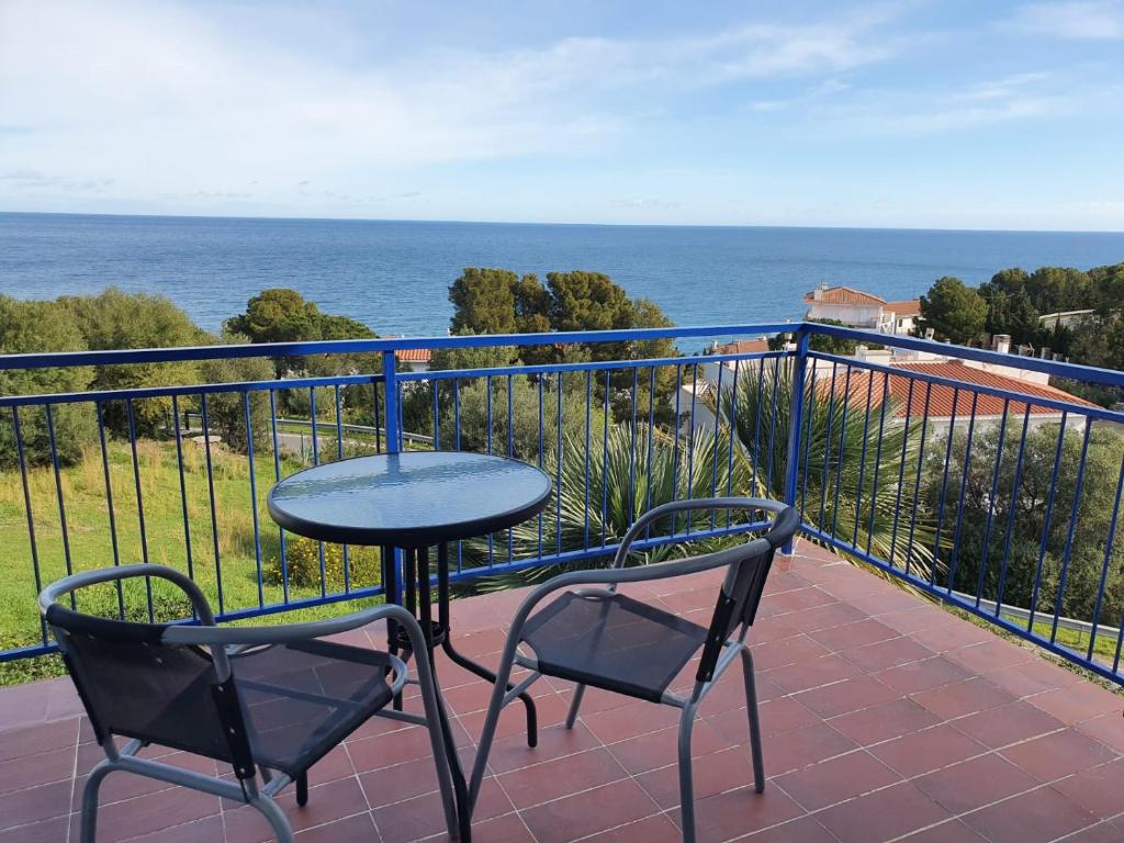 兰卡Habitacions Cau del Llop的阳台配有一张桌子和两把椅子,享有海景