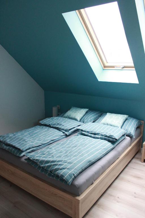 米卢夫卡Apartament Nad Góralem的蓝色客房的一张床位,设有天窗