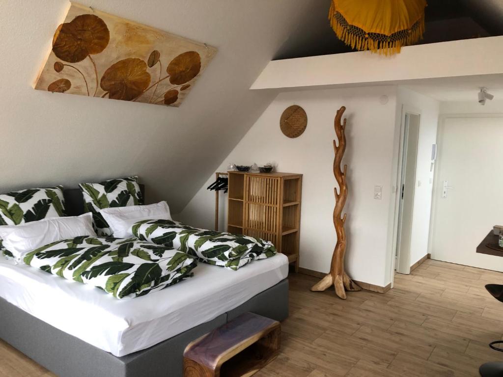 HüllhorstAppartement Bali的卧室配有一张床,墙上挂有绘画作品