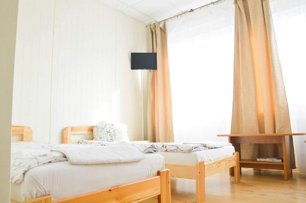 马里扬泊列TORINO lounge的一间卧室设有两张床、一张桌子和一个窗口