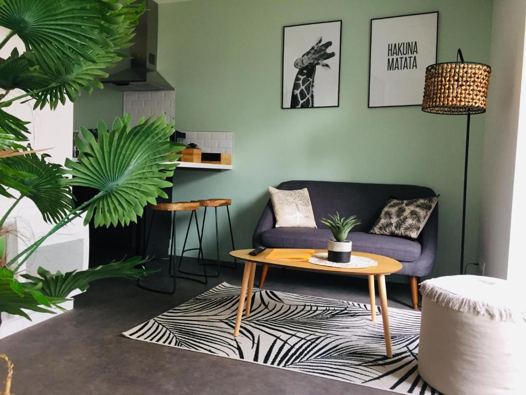 洛里昂Grand Studio avec terrasse proche de l'hypercentre de Lorient的客厅配有紫色沙发和桌子