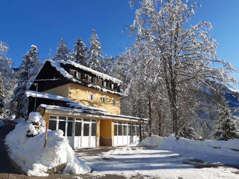 克拉尼斯卡戈拉Rooms Barovc by the Lake Jasna的一座被雪覆盖的房屋,有树木