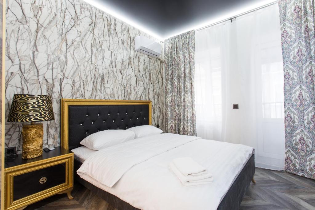 哈尔科夫Sumskaya Apartment Lux的一间卧室配有床和壁纸覆盖的墙壁