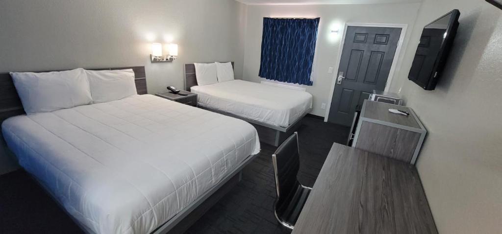HenryettaGreen Country Inn的一间酒店客房,设有两张床和电视