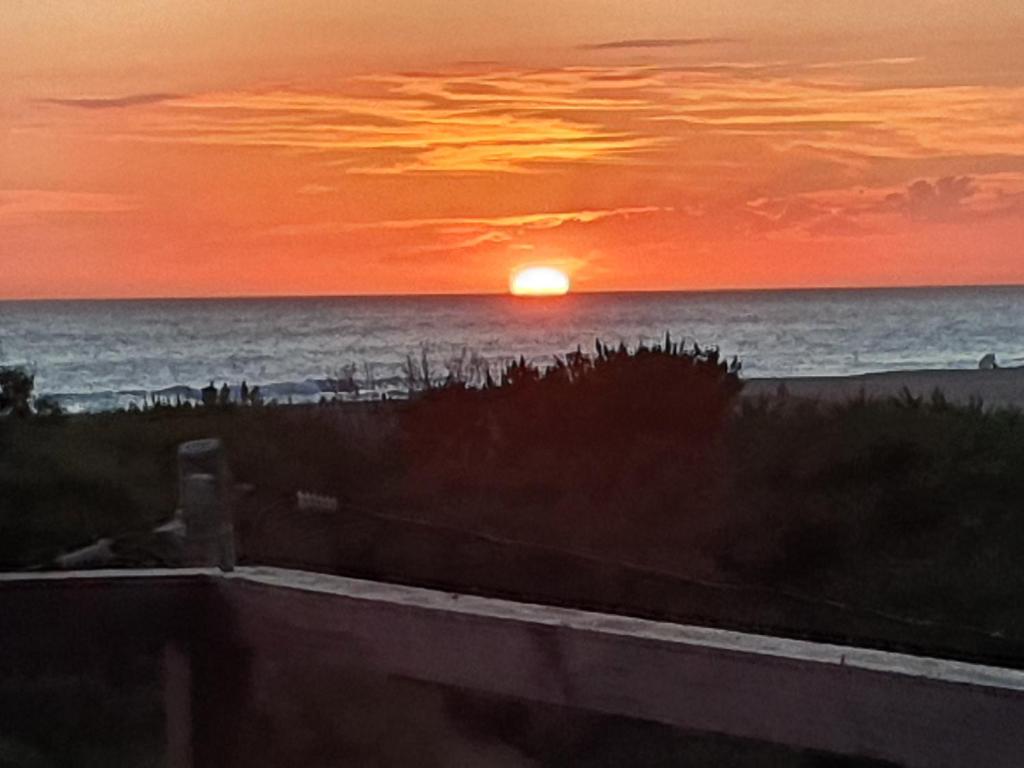 埃斯特角城Hotel Playa Chihuahua的海滩上的日落,背景是大海