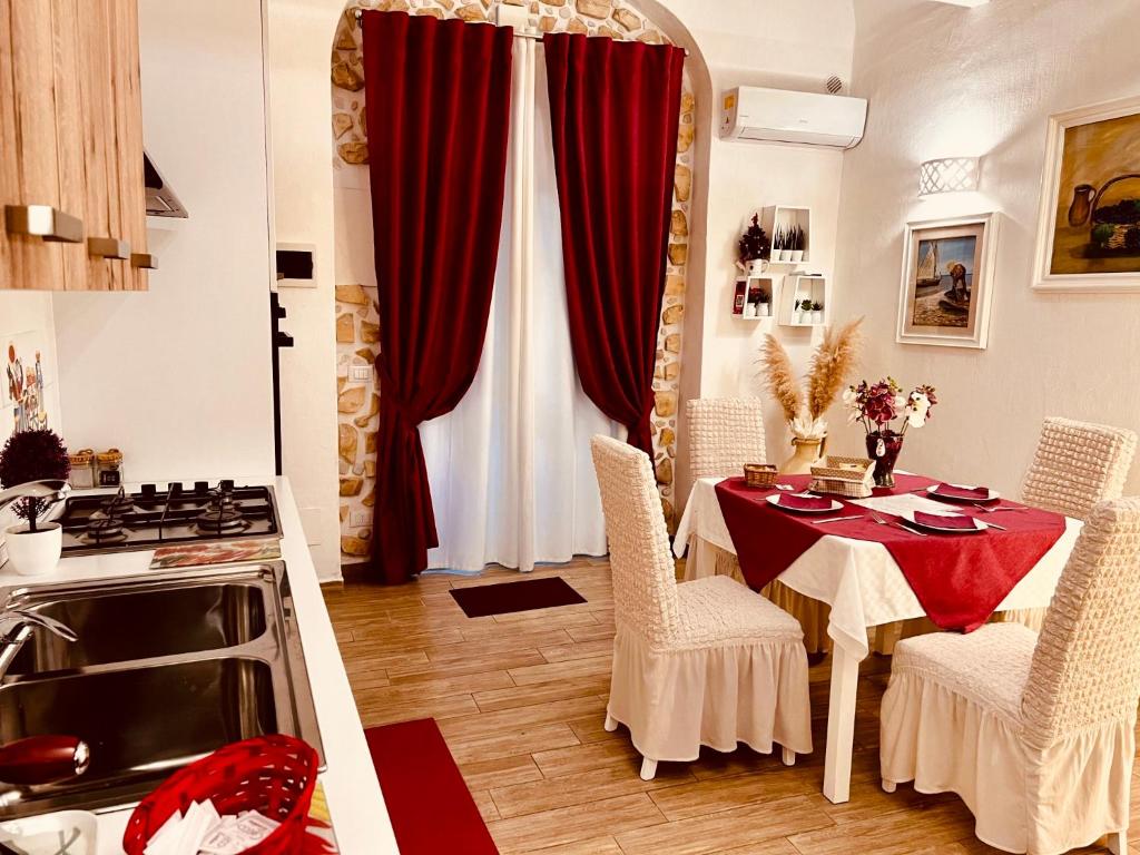 巴勒莫Le Chalet Palermo Centro的厨房配有带红色窗帘和炉灶的桌子