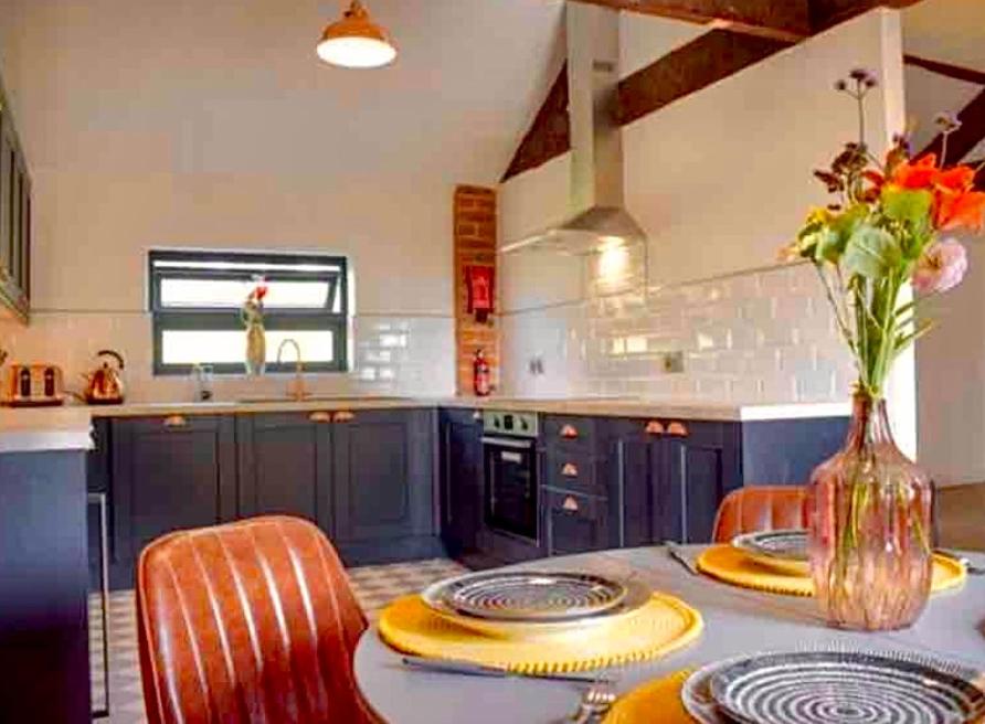 奥斯威斯Hayes Suite的厨房配有蓝色橱柜和桌椅