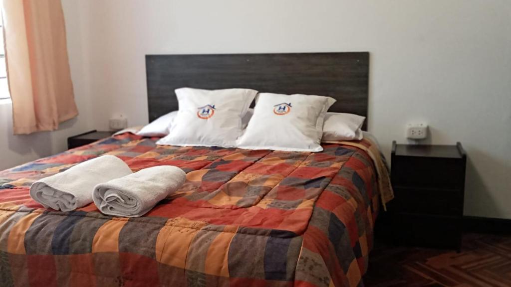 库斯科Qoricancha B&B Cusco的一间卧室配有带毛巾的床