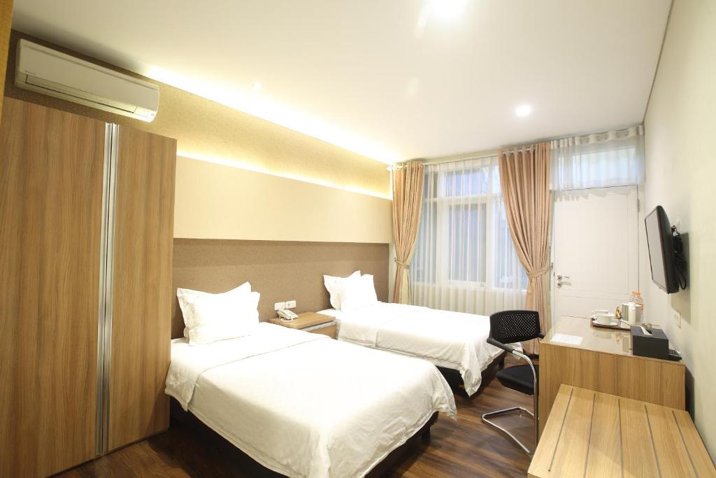 万隆达戈207号旅馆的酒店客房设有两张床和电视。