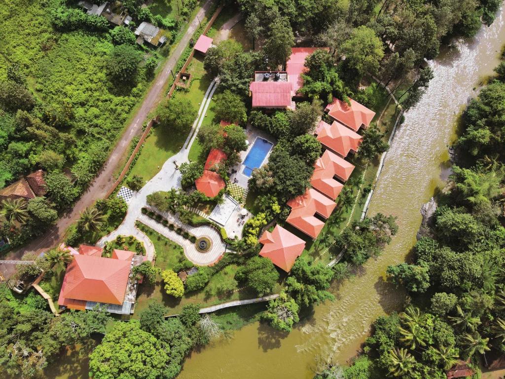 BegūrRegenta Jungle Resort Kabini Springs的享有河景房屋的空中景致