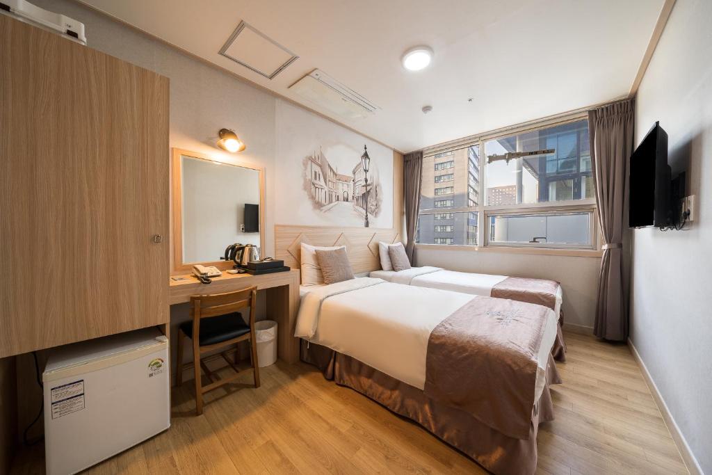 首尔明洞休闲酒店的配有床和书桌的酒店客房