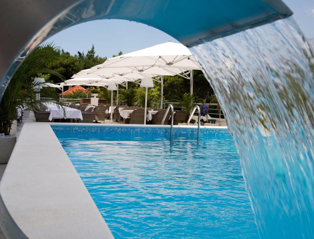 马卡尔斯卡米拉马尔公寓式酒店的游泳池前设有喷泉