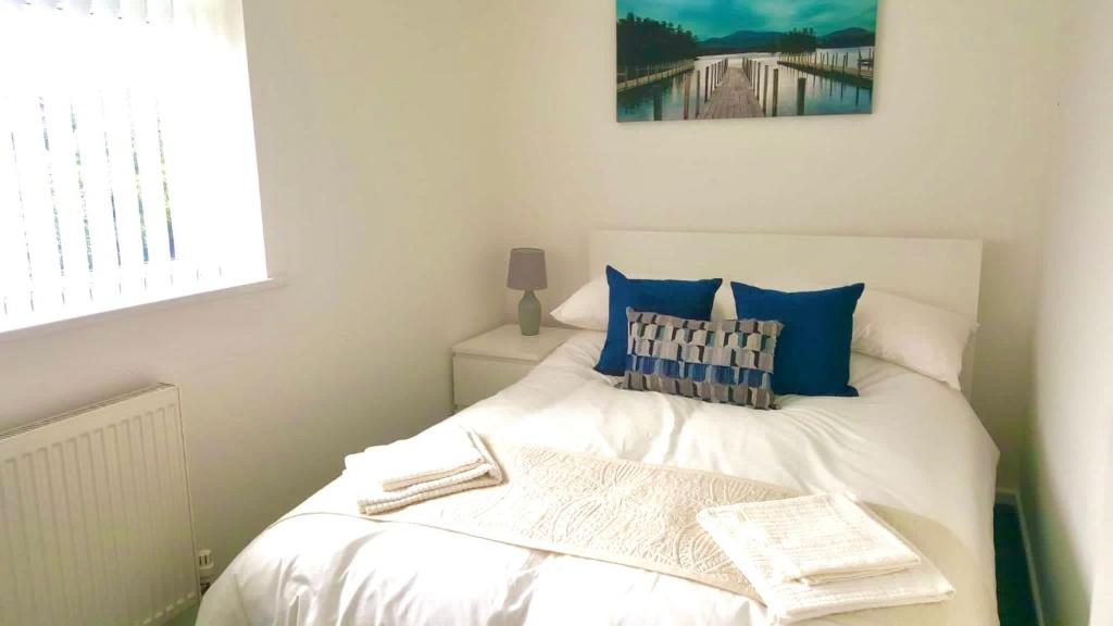 达灵顿Property Hunter 23的一间小卧室,配有白色的床和蓝色枕头