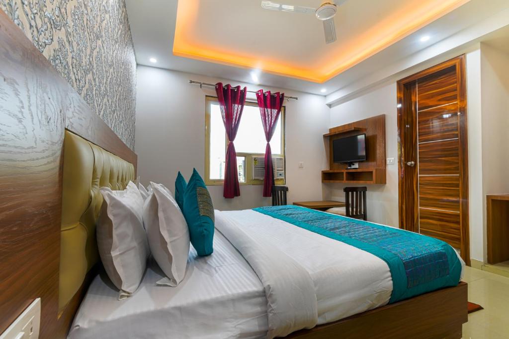 新德里Hotel Urban Tree的一间卧室配有一张大床和电视